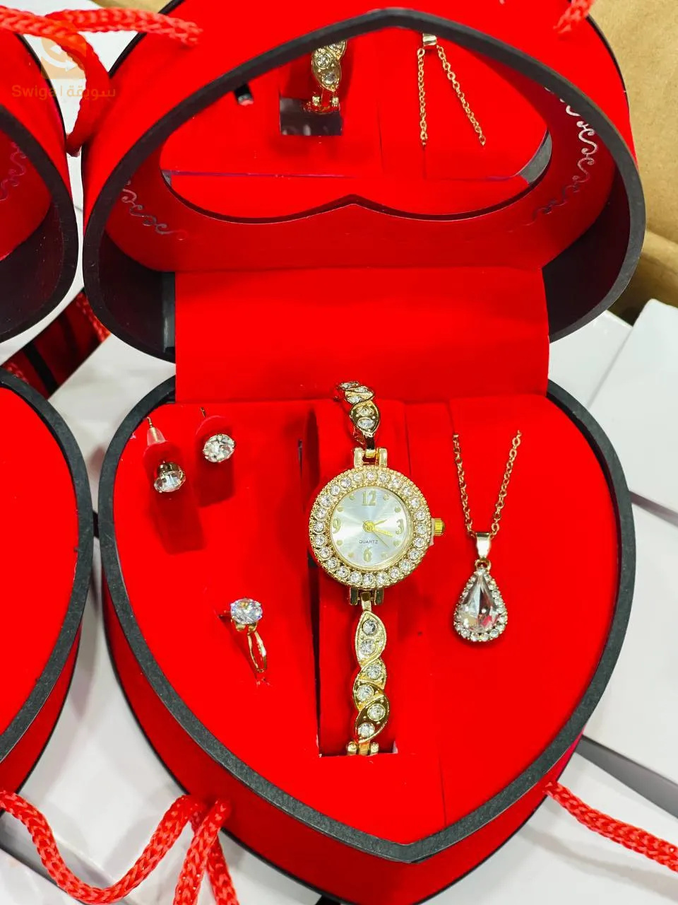 صندوق هدايا رائع يحمل ساعة، سلسلة، خاتم، وأقراط، يمكن أن يكون هدية مميزة لمن تحب.