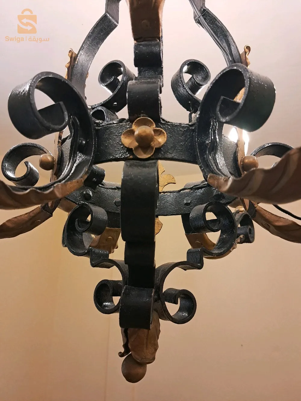 Gigantesque lustre, vintage, en fer forgé à six (06) bras de lumières, ornés de palettes dorées.