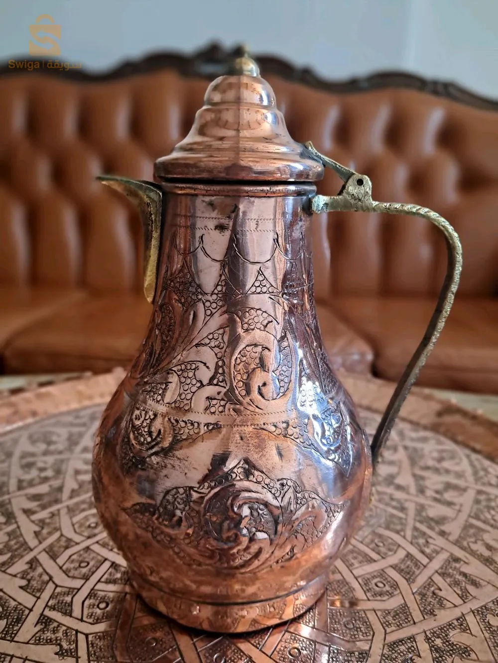 عرض بيع إبريقين للشاي وإبريق قهوة من النحاس. جميعها بأشكال وأحجام مختلفة، بمظهر حرفي ساحر وتقليدي.
