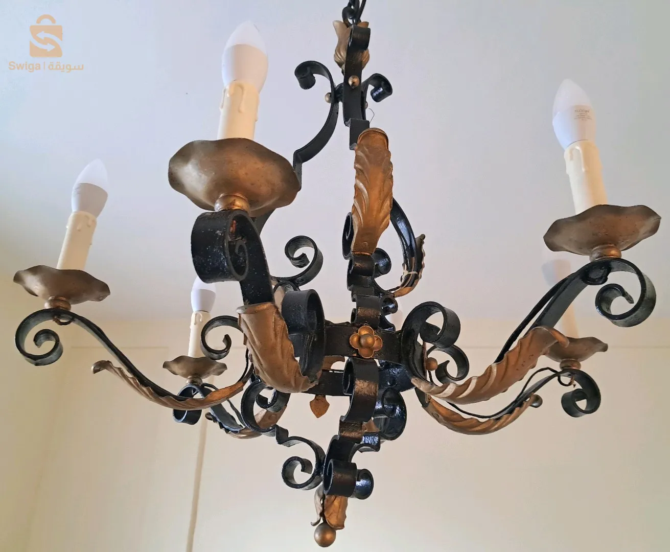 Gigantesque lustre, vintage, en fer forgé à six (06) bras de lumières, ornés de palettes dorées.