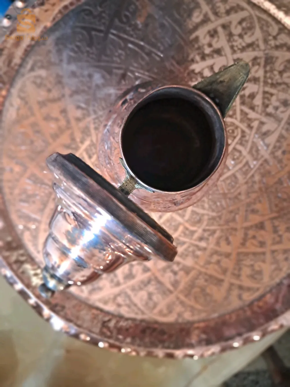 عرض بيع إبريقين للشاي وإبريق قهوة من النحاس. جميعها بأشكال وأحجام مختلفة، بمظهر حرفي ساحر وتقليدي.