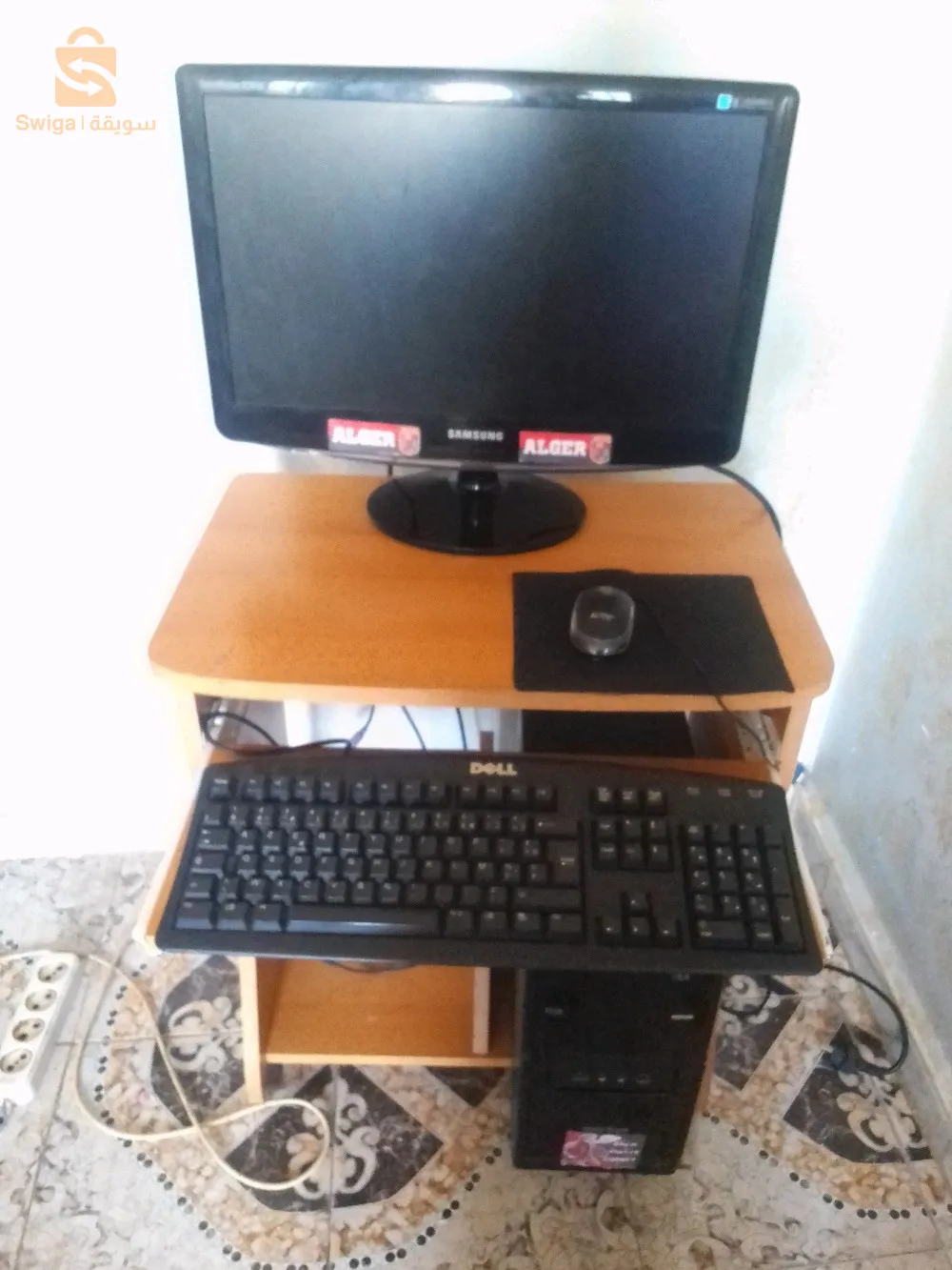 كمبيوتر مع مستلزماته وبالطاولة