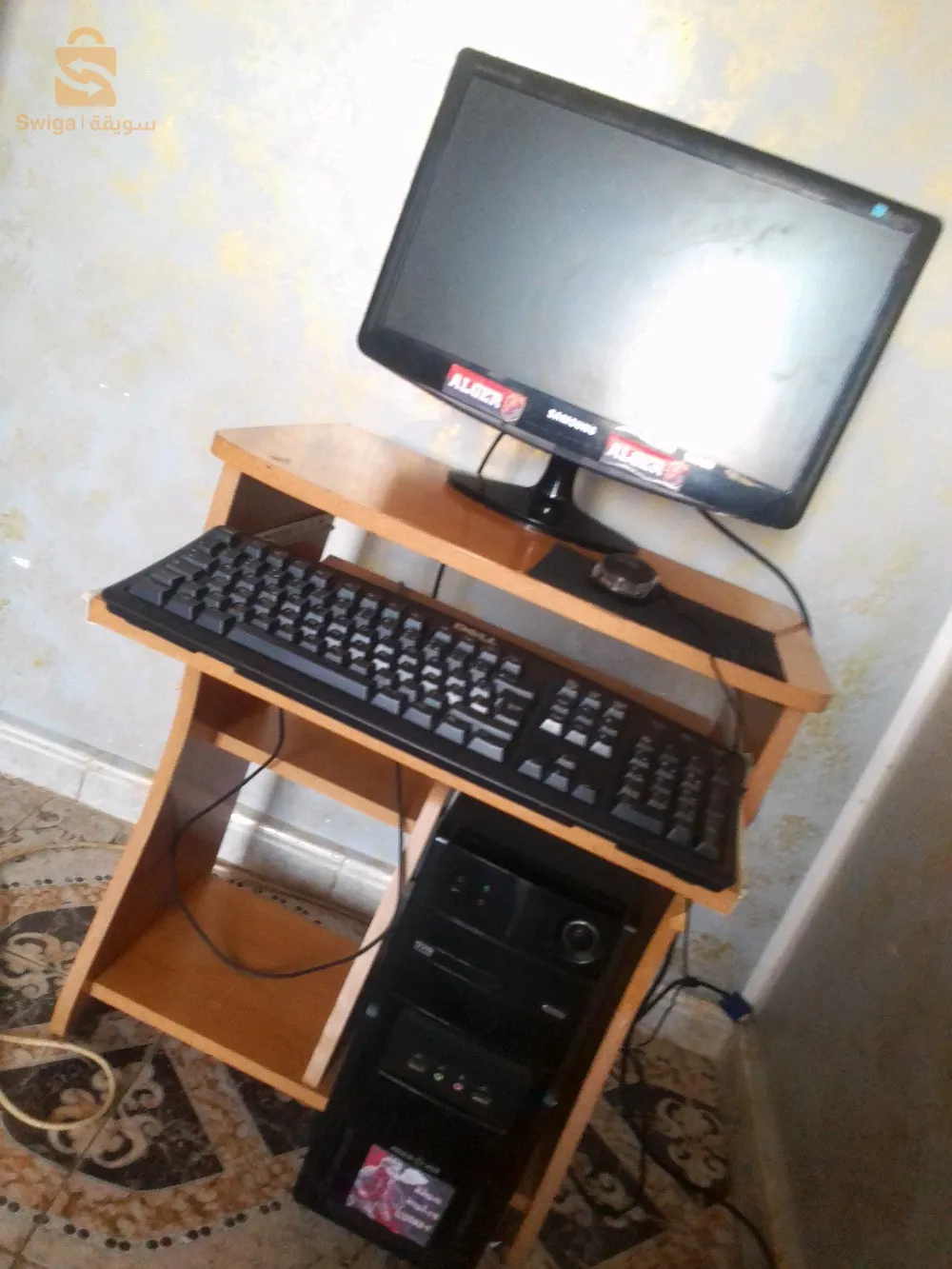 كمبيوتر مع مستلزماته وبالطاولة