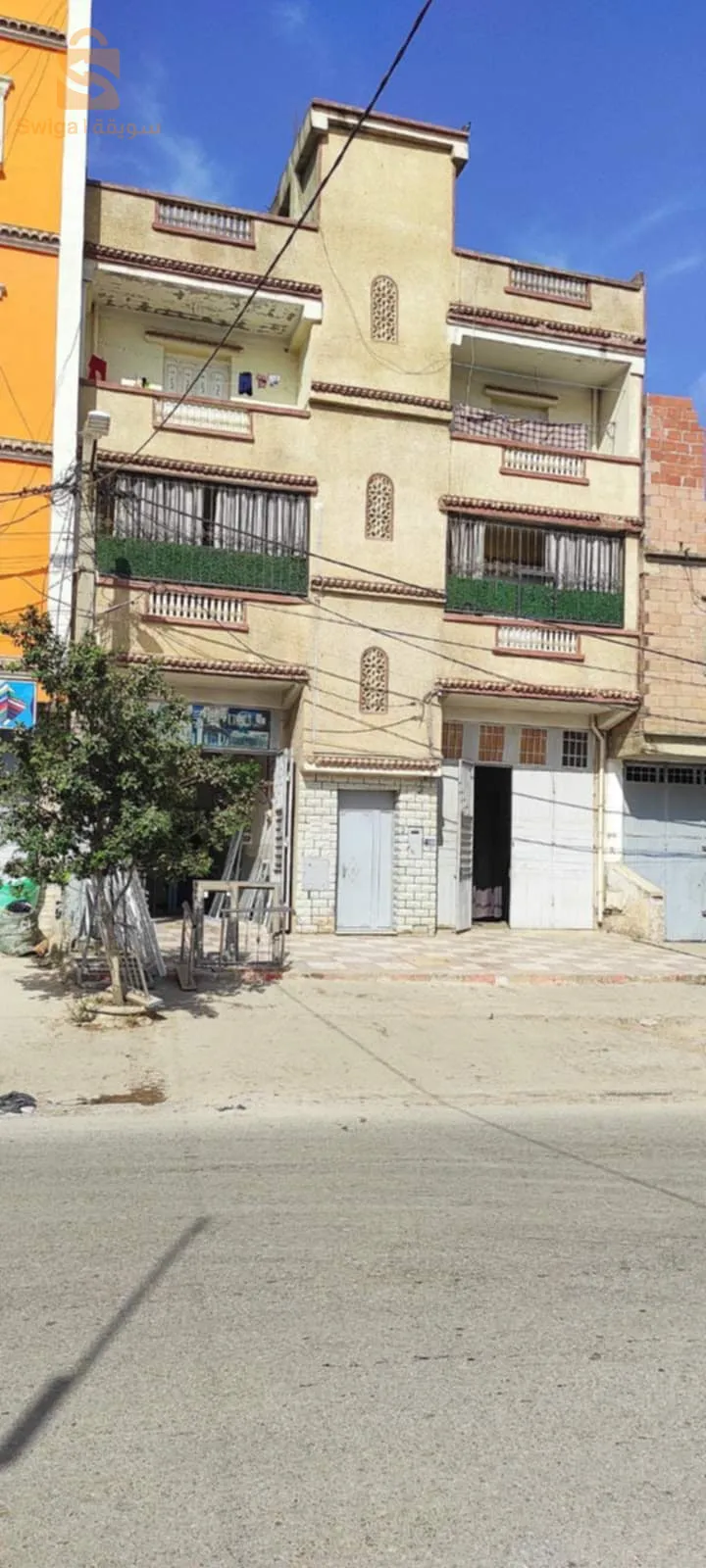 فيلا ذات طابقين و محلين في منطقة تجارية