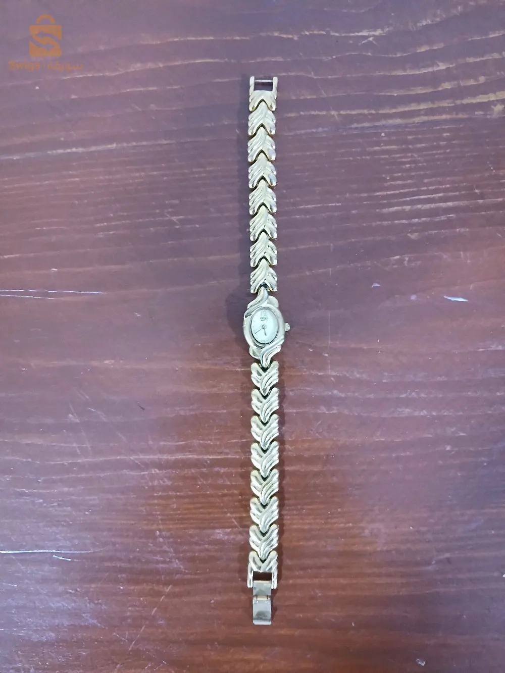 Montre vintage de la marque "Saicko" (probablement inspirée de la marque japonaise "Seiko"). Elle est dotée d'un bracelet en métal doré à motif en forme de feuilles, offrant un style élégant et classique. Le cadran est de petite taille, avec un affichage analogique, idéal pour ceux qui recherchent une montre raffinée au design rétro. Elle est en bon état et prête à être portée.