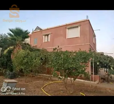 قطعة أرض 55آر للبيع بها منزل 200م قرب كل المرافق و الطريق السريع شرق غرب